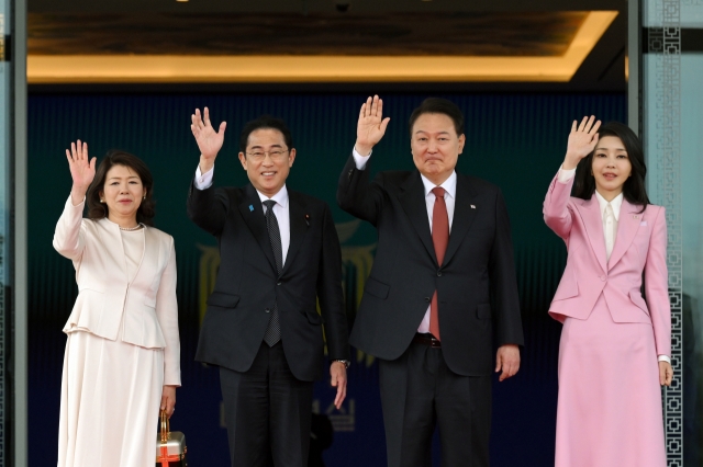 Japanese first lady Yuko Kishida (from left), Japanese Prime Minister Fumio Kishida, South Korean President Yoon Suk Yeol and South Korean first lady Kim Keon Hee wave hands as Kishida visited Seoul's presidential office in May 2023. (Presidential office)