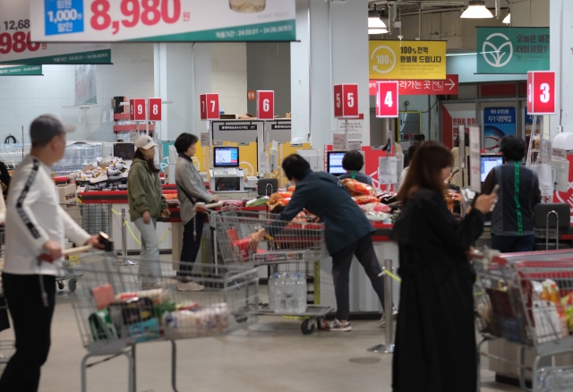 People stand in line to check out at a discount chain store in Seoul, Thursday. (Yonhap)