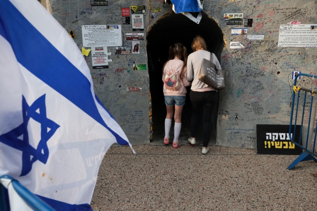 People look inside an installation of a tunnel created in support of hostages who were kidnapped during the deadly October 7 attack, amid the ongoing conflict in Gaza between Israel and the Palestinian Islamist group Hamas, in Tel Aviv, Israel, Tuesday. (Reuters-Yonhap)