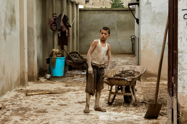 A boy looks on while standing next to a wheelbarrow, in the aftermath of floods following heavy rain, in Sheikh Jalal District, Baghlan province, Afghanistan May 11, 2024. (Reuters/Sayed Hassib)