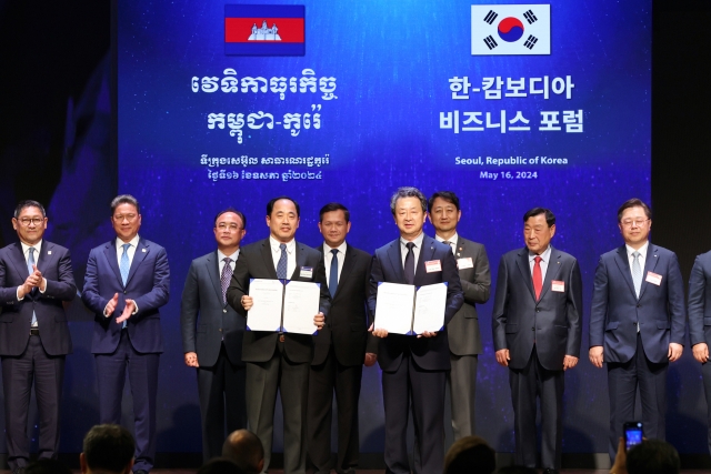 Daewoo E&C CEO Baek Jeong-wan (sixth from left) and WorldBridge Group Chairman Rithy Sear (fourth from left), along with South Korean Industry Minister Ahn Duk-geun (seventh from left) and other officials, attend an MOU signing event held during the Cambodia-Korea business forum at the Korea Chamber of Commerce and Industry, Seoul, Thursday. (Daewoo E&C)