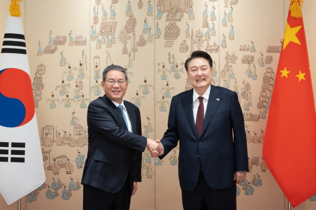 President Yoon Suk Yeol (right) and Chinese Premier Li Qiang pose for a photo during their meeting at the presidential office in Seoul on Sunday. (Yonhap)