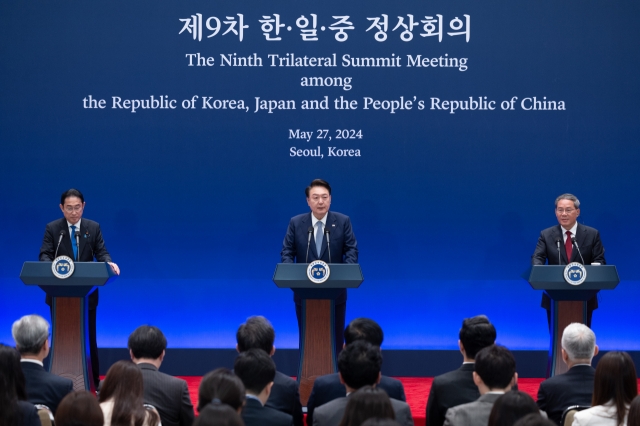 President Yoon Suk Yeol (center) speaks during a joint press briefing of the ninth trilateral summit with Japanese Prime Minister Fumio Kishida (left) and Chinese Premier Li Qiang at the former presidential office of Cheong Wa Dae in Seoul on Monday. (Yonhap)