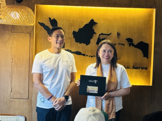 Indonesia’s Minister for Tourism and Creative Economy Sandiaga Uno and Indonesian charge d'affairs a.i. Zelda Wulan Kartikaat shjowcase batik at an Indonesian Restaurant in Mapo-gu, Seoul on May 10. (Sanjay Kumar/ The Korea Herald)