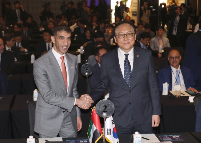 South Korean Trade Minister Cheong In-kyo (right) shakes hands with UAE Minister of State for Foreign Trade Thani bin Ahmed Al Zeyoudi at the Korea-UAE Business Investment Forum in Seoul on Tuesday. (Yonhap)