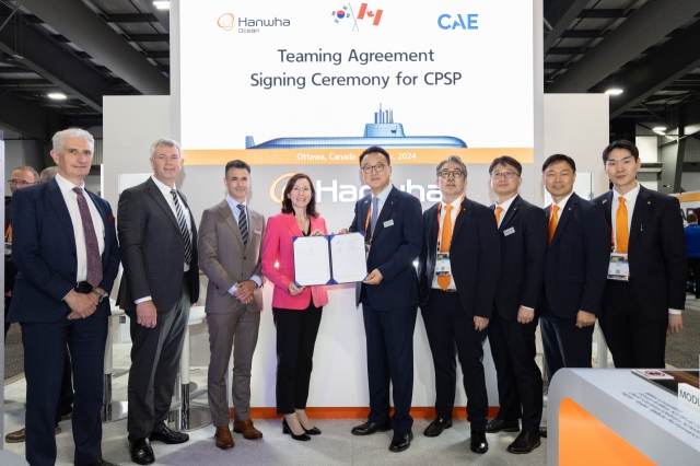 Officials from Hanwha Ocean and CAE pose for a photo after signing a teaming agreement at the CANSEC in Ottawa. (Hanwha Ocean)