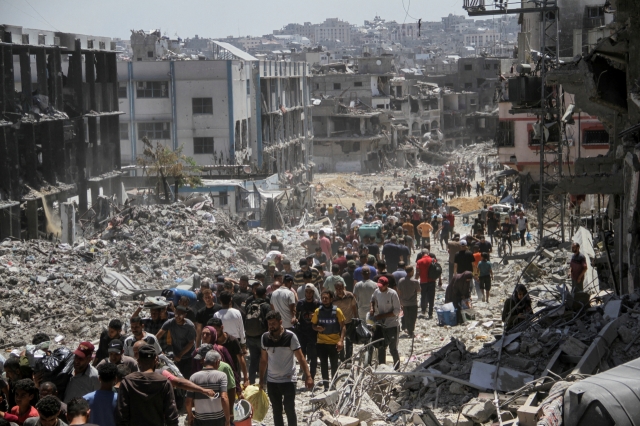 Palestinians make their way as they inspect damages after Israeli forces withdrew from a part of Jabalia refugee camp, following a raid in the northern Gaza Strip, Thursday. (Reuters)