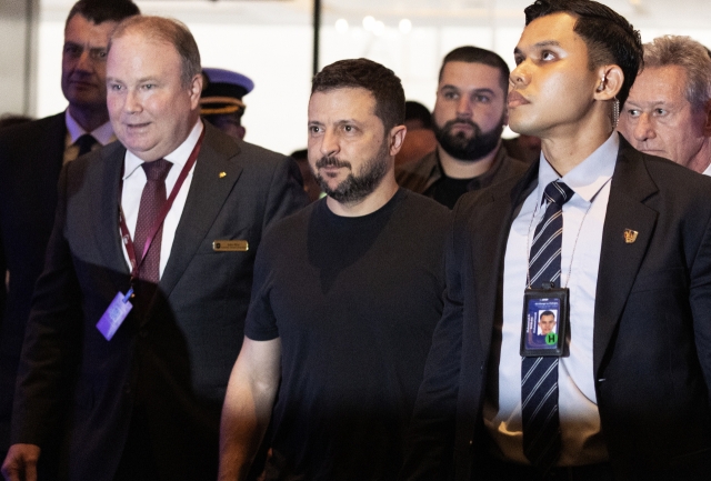 Ukraine President Volodymyr Zelensky (center) arrives at the Shangri-la Hotel to attend the International Institute for Strategic Studies 21th Shangri-La Dialogue in Singapore on Saturday. (EPA-Yonhap)