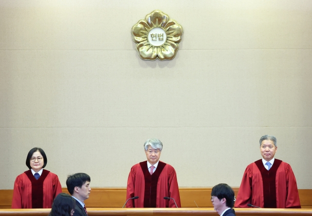 Justices of the Constitutional Court of Korea stand as they are ready to hand down verdicts Thursday. (Yonhap)