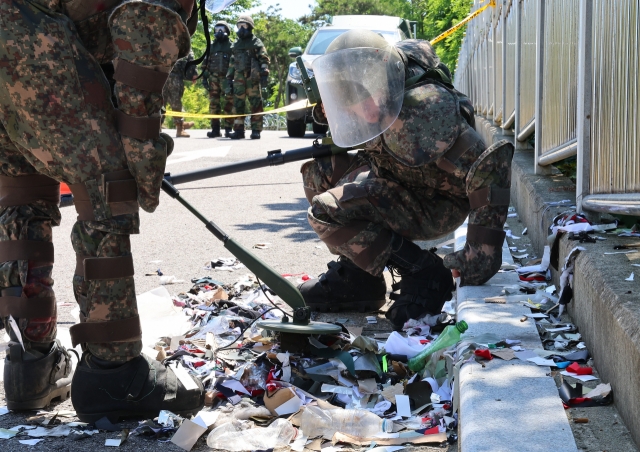 South Korean military personnel inspect remnants of a trash-filled balloon floated over from North Korea to Incheon. Using mine detectors, they check the safety of the balloon's contents, Sunday. (Yonhap)