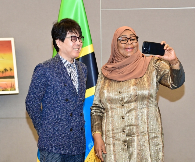 President Samia Suluhu Hassan of Tanzania (right) takes a selfie with South Korean singer Cho Yong-pil after a meeting held at the JW Marriott Hotel in Seoul on Monday. (Tanzanian Presidential Office)