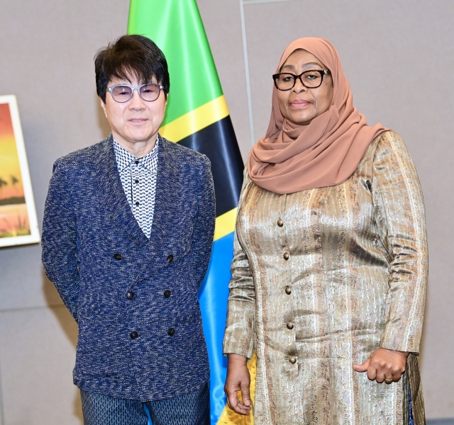 President Samia Suluhu Hassan of Tanzania (right) and South Korean singer Cho Yong-pil pose for a photo after a meeting held at the JW Marriott Hotel in Seoul on Monday. (Tanzanian Presidential Office)