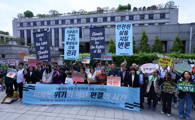 Plaintiffs, lawyers and activists gather outside of South Korea’s Constitutional Court in Jongno-gu, central Seoul, ahead of a public hearing concerning a climate lawsuit on April 23. A total of four lawsuits have been filed against the government for violating people's human rights by not effectively tackling climate change. (Newsis)