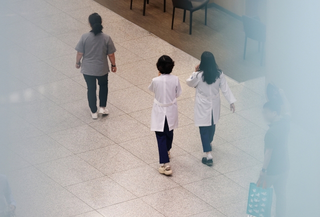 Medical workers walk in a hallway at a university hospital in Seoul on Monday. (Yonhap)