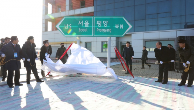 Officials from South and North Korea unveil a road sign during the ceremony for a project to modernize and connect roads and railways over the border between the Koreas at Panmun Station on December 26, 2018 in Kaesong, North Korea. (Getty images)