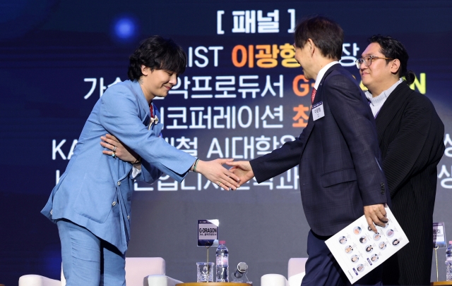 G-Dragon shakes hands with KAIST President Lee Kwang-hyun during his appointment as a visiting professor at KAIST at the Innovate Korea forum held at the KAIST campus in Daejeon, Wednesday. (Yonhap)