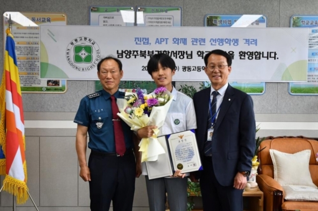 Kim Min-jun (center) poses with officials from Namyangju Bukbu Police Station after receiving a certificate of appreciation for helping residents evacuate in the June 1 fire. (Namyangju Bukbu Police Station)