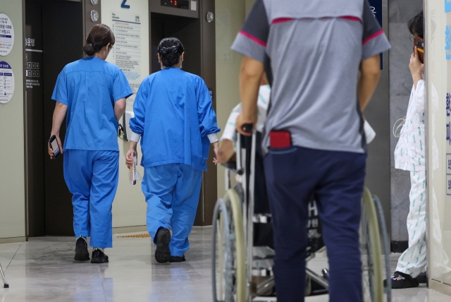 Medical personnel and patients walk in a general hospital in Seoul. (Yonhap)