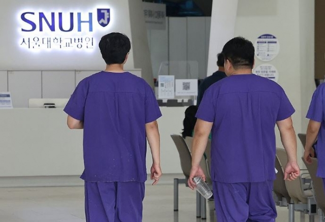 Doctors walk along a corridor at Seoul National University Hospital in Seoul on June 6, 2024. (Yonhap)