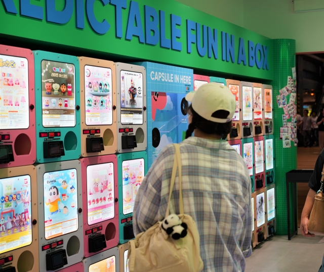 A customer looks at colorful capsule vending machines at Play In The Box in Gangnam-gu, southern Seoul. (Lee Si-jin/The Korea Herald)