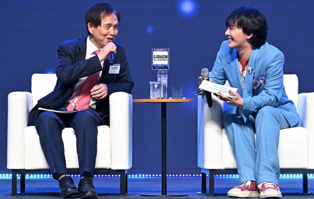 G-Dragon (right) converses with KAIST President Lee Kwang-hyung during a special session at the Innovate Korea forum held at KAIST Lyu Keun-chul Sports Complex in Daejeon on Wednesday. (Lee Sang-sub/The Korea Herald)