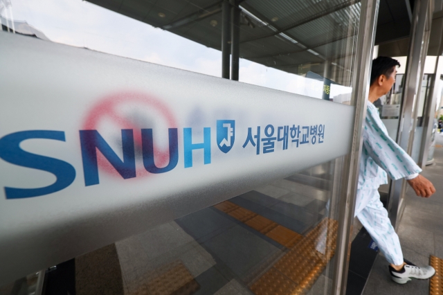 A patient walks out a building of the Seoul National University Hospital in Seoul on Thursday.