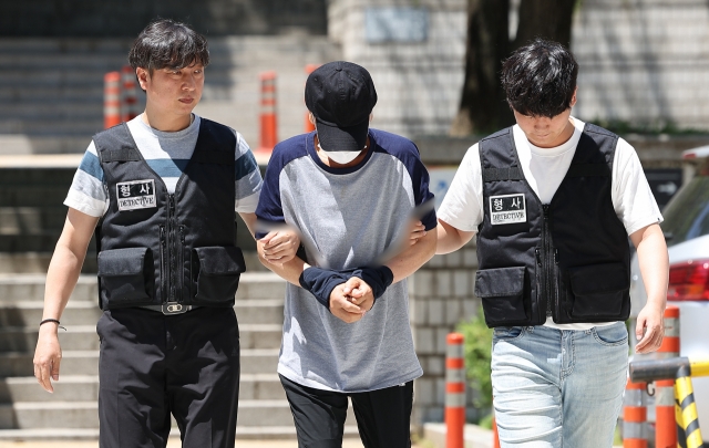 Park Hak-sun, who is accused of murdering a woman in her 60s and her daughter in her 30s at an office in Gangnam district, is escorted to an arrest warrant hearing on Sunday. (Yonhap)