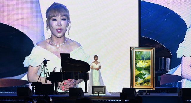 Soprano Sumi Jo performs a duo with a voice generated by artificial intelligence during Innovate Korea 2024 at the Lyu Keun-chul Sports Complex in KAIST in Yuseong-gu, Daejeon, on June 5. (Im Se-jun/The Korea Herald)