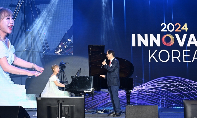 Soprano Sumi Jo (left) sings with KAIST President Lee Kwang-hyung during Innovate Korea 2024 at the Lyu Keun-chul Sports Complex at KAIST in Yuseong-gu, Daejeon, on June 5. (Im Se-jun/The Korea Herald)