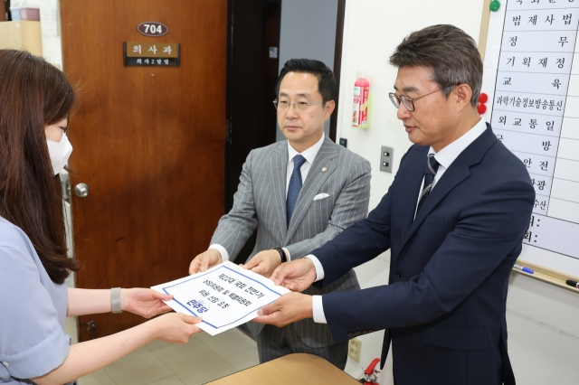 Democratic Party lawmakers file a document containing the list of nominees for the members of the standing committees for the first two years of the 22nd National Assembly with the proceeding division in western Seoul on Friday. (Yonhap)