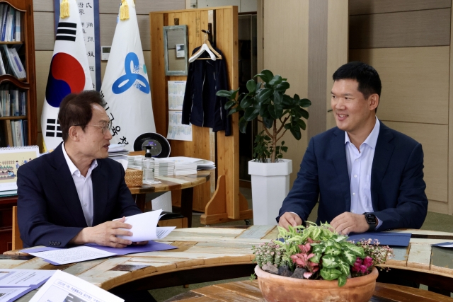 GS E&C CEO Huh Yoon-hong (right) talks with Cho Hee-yeon, the superintendent of the Seoul Metropolitan Office of Education, during the after-school care partnership event held at Cho's office in Seoul on Monday. (GS E&C)