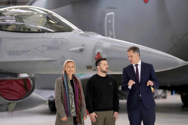 Belgium's Prime Minister Alexander De Croo (right) and Belgium's Defense Minister Ludivine Dedonder (left) pose with Ukraine's President Volodymyr Zelenskyy in front of an F-16 at Melsbroek military airport in Brussels, on May 28, 2024.