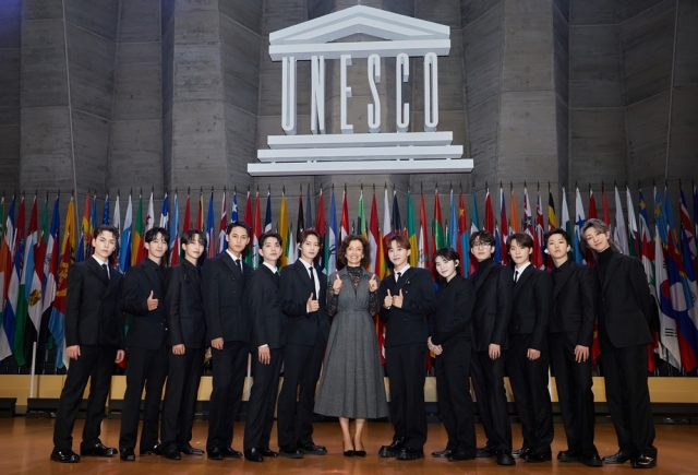 The bandmates of K-pop boy band Seventeen pose with Director General of UNESCO Audrey Azoulay (center) during the 13th UNESCO Youth Forum held at the UNESCO headquarters in Paris in November 2023. (Pledis Entertainment)