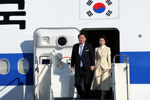 President Yoon Suk Yeol (left) and first lady Kim Keon Hee arrive at Astana International Airport in the Kazakh capital on Tuesday. (Yonhap)