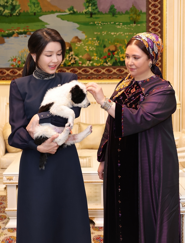 South Korean first lady Kim Keon Hee (left) holds a Turkmen shepherd dog during her visit with the host's first lady on Monday, in Ashgabat, Turkmenistan. President Yoon Suk Yeol and Kim met Turkmen President Serdar Berdymukhamedov and his wife, about whom information has not been revealed. (Pool photo via Yonhap)