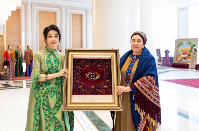 South Korean first lady Kim Keon Hee (left) poses for a photo with Ogulgerek Berdymukhamedova, wife of Turkmen People's Council Chair Gurbanguly Berdymukhamedov, Tuesday in Ashgabat, Turkmenistan. (Pool photo via Yonhap)