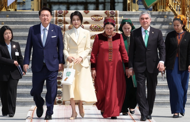 President Yoon Suk Yeol (second from left), first lady Kim Keon Hee (third from left), Turkmen People's Council Chair Gurbanguly Berdymukhamedov (second from right) and his wife Ogulgerek Berdymukhamedova (fourth from right) walk together at Ashgabat International Airport in Turkmenistan, Tuesday. (Yonhap)