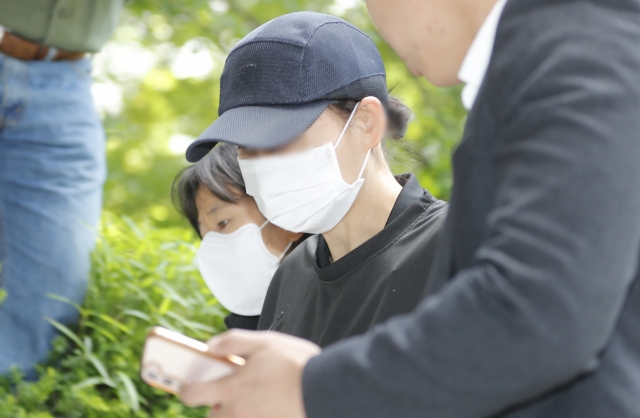 Police officers escort a member of a local church accused of murdering 17-year-old girl at the Incheon District Court on May 18, 2024. (Newsis)