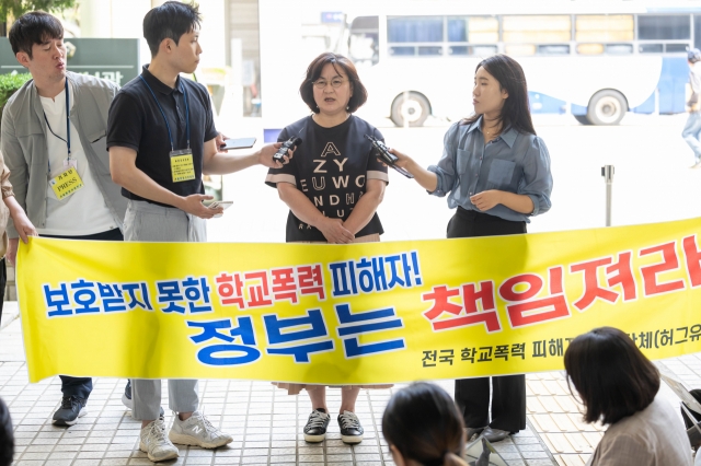 Lee Gi-cheol (second from right), the mother of a teenage girl who died in a school bullying case, speaks to reporters Tuesday at the Seoul Central District Court, after partially winning a civil case against her lawyer. The lawyer’s repeated failure to show up to hearings in the suit against the school bullies resulted in Lee and her family losing the case. (Yonhap)