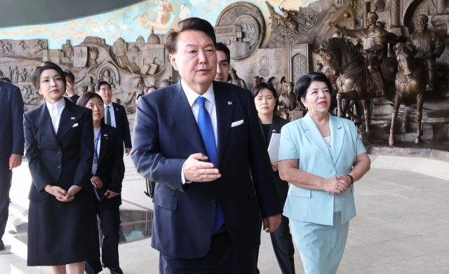 President Yoon Suk Yeol (third from right) and first lady Kim Keon Hee (left) visit the Independence Square of Uzbekistan in Tashkent, Uzbekistan, on Thursday. (Yonhap)