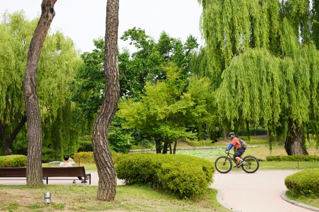 People enjoy their time on the walking trail near Yongyeon Pond on Tuesday. (Lee Si-jin/The Korea Herald)