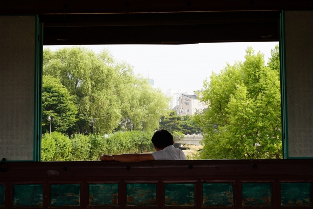 A visitor enjoys a cool breeze blowing inside the pavilion at Hwahongmun Watergate in Suwon, Gyeonggi Province on Tuesday. (Lee Si-jin/The Korea Herald)