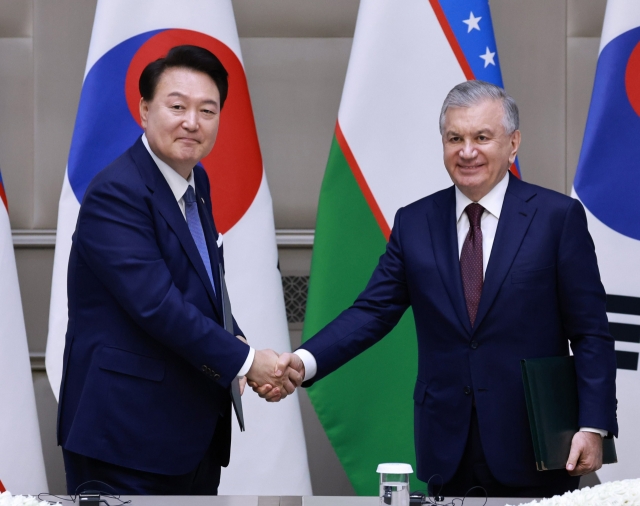 President Yoon Suk Yeol (left) and Uzbek President Shavkat Mirziyoyev shake hands before the joint press conference held at the Kuksaroy Presidential Palace in Tashkent, Uzbekistan on Friday. (Yonhap)