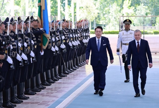 President Yoon Suk Yeol (third from right) and Uzbek President Shavkat Mirziyoyev (right) enter the Kuksaroy Presidential Palace for a summit in Tashkent, Uzbekistan on Friday. (Yonhap)