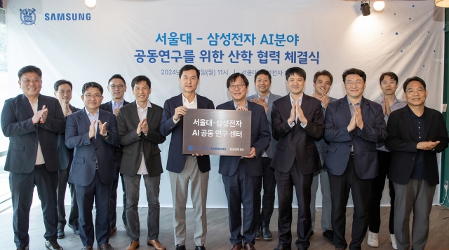 Cheun Kyung-whoon, president and chief technology officer at Samsung Electronics' DX division (center left), Kim Young-oh, dean of SNU College of Engineering (center right), company and university officials pose for a photo after the signing ceremony held at the school in Seoul on Monday. (Samsung Electronics)