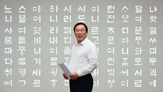 Sejong Mayor Choi Min-ho poses in front of a mural depicting a section of the Hunminjeongeum, the original Hangeul study guide, for an interview at his office on June 4. (Park Hae-mook/The Korea Herald)