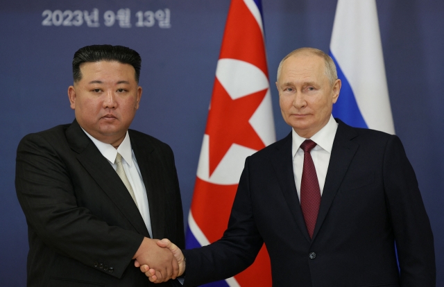 Russian President Vladimir Putin (right) and North Korea's leader Kim Jong Un (L) shaking hands during their meeting at the Vostochny Cosmodrome in Amur region on September 13, 2023. (Pool Photo via AFP)