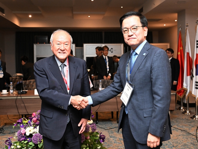 South Korea's Finance Minister Choi Sang-mok (right) shakes hands with his Japanese counterpart, Shunichi Suzuki, ahead of a trilateral meeting with their Chinese counterpart in Georgia on May 3. (The finance ministry)