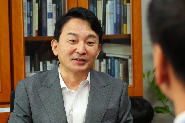 Won Hee-ryong, a former minister of Land, Infrastructure, and Transport who has declared his candidacy for the July 23 convention of the People Power Party, talks with lawmaker Kim Ki-hyun at the National Assembly's parliamentary chamber Friday. (Yonhap)