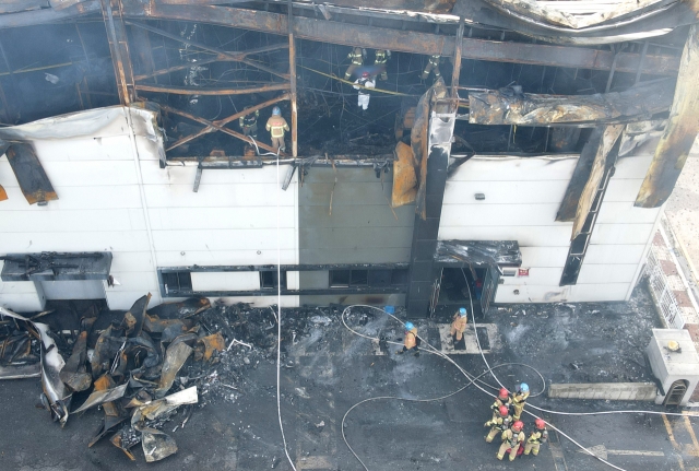 Firefighters retrieve the bodies of workers at the site of a fire at a primary lithium battery factory in Hwaseong, 45 kilometers south of Seoul, on June 24, 2024. The fire left at least 22 workers dead. (Yonhap)